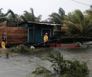 Dos hombres caminan por los perímetros de una casa rodeados por las inundaciones provocadas por el huracán Eta en Wawa, Nicaragua, el martes 3 de noviembre de 2020. (AP Foto/Carlos Herrera)