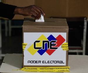 A woman casts her vote during the presidential election at a polling station in Caracas on May 20, 2018. Venezuelans headed to the polls early Sunday to vote in the general elections as incumbent president Nicolas Maduro is seeking a second term in power. / AFP PHOTO / Federico PARRA