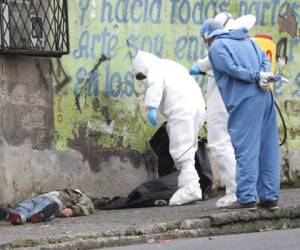 Forensic investigators look at the body of a man infected with the new coronavirus who collapsed on the street and died, according to Police Captain Diego Lopez, in Quito, Ecuador, Tuesday, May 5, 2020. (AP Photo/Dolores Ochoa)