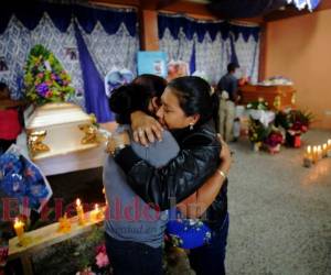 Familiares de Marlon y Gerardo se abrazan frente a los ataúdes de los muchachos. Foto: Estalin Irías/EL HERALDO.