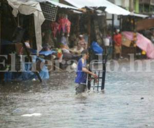 Lluvia de 30 minutos inundó los mercados de Comayagüela. Los vendedores tratan de rescatar su mercadería. Foto David Romero/EL HERALDO
