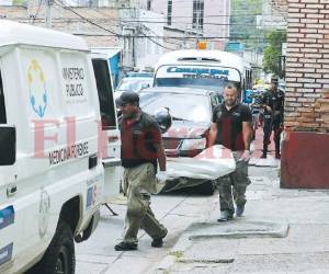 Momento del levantamiento del cuerpo del joven asesinado por el personal de Medicina Forense. Foto: Estalin Irías/ EL HERALDO