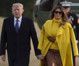 Donald Trump camina en el jardín de la Casa Blanca mientras intenta dar la mano a Melania sin éxito. Fotos AFP