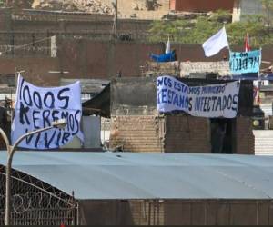 Los reos protestaron con los torsos desnudos y con carteles en los techos. Foto: AFP