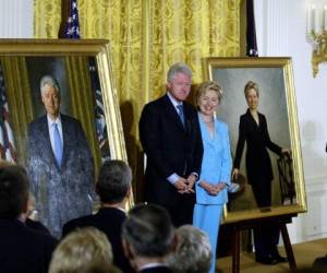 En esta foto de archivo tomada el 14 de junio de 2004, el ex presidente de los Estados Unidos Bill Clinton y la senadora Hillary Clinton respaldan sus retratos oficiales de la Casa Blanca. Foto: AFP