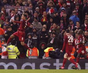 En imagen de archivo del 11 de marzo de 2020, el delantero brasileño Roberto Firmino, izquierda, festeja tras anotar el segundo gol del club Liverpool durante un duelo de la Liga de Campeones frente al Atlético de Madrid, en el estadio Anfield de Liverpool, Inglaterra. Foto: Agencia AP.