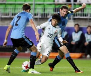 Japan's Takefusa Kubo, center, fights for the ball with Uruguay's Agustin Rogel, right, and Santiago Bueno during their Group D soccer match in the FIFA U-20 World Cup Korea 2017 at Suwon World Cup Stadium in Suwon, South Korea, Wednesday, May 24, 2017. (Im Hun-jung/Yonhap via AP)