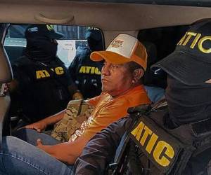 Miembros de ATIC escoltando al exmilitar Santos Rodríguez Orellana después de ser arrestado por cargos de lavado de activos, en Tegucigalpa. Foto AFP