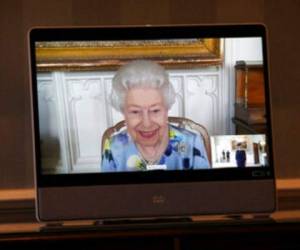 La reina Isabel II de Gran Bretaña en una pantalla durante una videollamada desde el Castillo de Windsor, donde está residiendo, en una audiencia virtual para recibir a su excelencia Ivita Burmistre, embajadora de Letonia, en el Palacio de Buckingham. Foto: AP