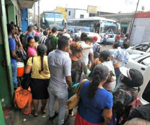 Pasajeros esperan para abordar estas dos unidades con rumbo a la zona norte y atlántico de Honduras. Foto: Johny Magallanes / El Heraldo.
