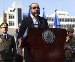 El Salvador's President Nayib Bukele, accompanied by members of the armed forces, speaks to his supporters outside Congress in San Salvador, El Salvador, Sunday, Feb. 9, 2020. Bukele has called on supporters to converge around the country's parliament after legislators refused to gather to vote on a $109 million loan to better equip the country's security forces. Top commanders of the country's police and military have expressed allegiance to the president during the standoff, while positioning security forces around the legislative building. (AP Photo/Salvador Melendez)