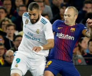 Iniesta peleando el balón con Benzemá en el clásico español entre Barcelona y Real Madrid. (AP)