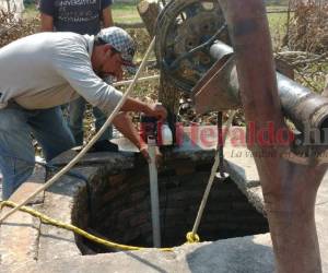 Miembros del Cuerpo de Bomberos intentan rescatar el cadáver. Foto EL HERALDO
