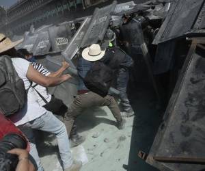 El recorrido inició en el Ángel de la Independencia como una marcha pacífica y terminó en la plaza más grande del país, donde el bloque negro de la manifestación golpeó con martillos y piedras las vallas que resguardaban el Palacio Nacional hasta derribarlas. Aquí las imágenes de los fuertes disturbios.