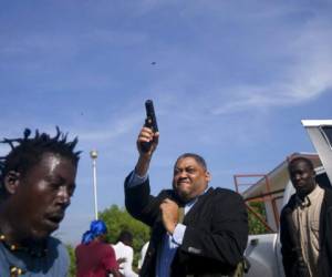 Ralph Fethiere dispara su pistola afuera del Parlamento al llegar a una votación para ratificar la nominación de Fritz William Michel como primer ministro en Puerto Príncipe. Foto: AP.