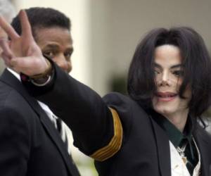 El ícono del pop Michael Jackson saluda a admiradores al llegar a su juicio por presunto abuso sexual de menores en el Tribunal Superior de Santa Bárbara, en Santa María, California. (AP Foto/Michael A. Mariant, Archivo).