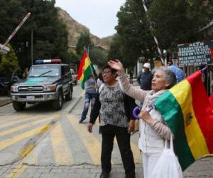 Varias personas protestan en la entrada que conduce a la embajada mexicana para asegurarse de que nueve exfuncionarios del gobierno del expresidente boliviano Evo Morales, que se han refugiado en el interior, no salgan del país en La Paz, Bolivia. Foto: AP.