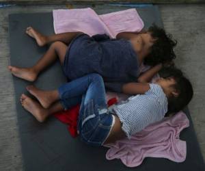 Unos niños migrantes duermen sobre una colchoneta en el albergue AMAR en Nuevo Laredo, México, en la frontera con Estados Unidos, el miércoles 17 de julio de 2019.