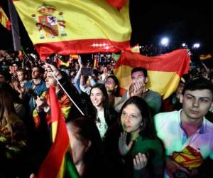 Los partidarios del partido español de extrema derecha VOX ondean banderas mientras escuchan a su líder Santiago Abascal. Foto AFP