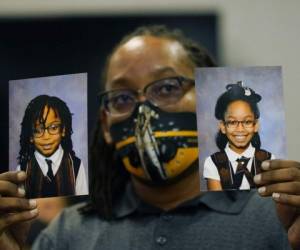 Sheldon Smith, muestra las fotografías de sus hijos Deshawn Smith, 11, izquierda; y Trinitee Smith, 13, ambos aquejados de anemia de células falciformes, en un acto por la Iniciativa 65 en Rigeland, Mississippi. Smith y su esposa Keishawna Smith dicen que sus hijos se beneficiarían de tratamiento con marihuana medicinal ara el dolor. Foto: AP.