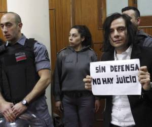 Cristian Aldana, cantante principal de la banda de rock 'El Otro Yo', sostiene un letrero que dice en español 'Sin defensa legal no hay juicio'. Foto AP
