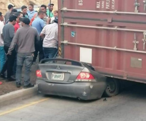 Momento en que las personas tratan de ayudar al joven atrapado en el vehículo.
