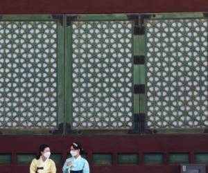 Mujeres con mascarilla para combatir los contagios de coronavirus en el palacio de Gyeongbok en Seúl, el lunes 17 de agosto de 2020.
