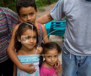 En esta foto del 2 de noviembre de 2018, Brithani Lizeth Cardona Orellana, de 3 años, en el centro inferior derecho, está con su hermana Janeisy Nicolle, de 5 años, y su hermano Kenner Alberto, de 9 años, flanqueados por su tía y tío en su casa en San Pedro Sula, Honduras. Los padres de los niños están a cientos de kilómetros y dos países que los separa de Honduras, dirigiéndose hacia los Estados Unidos con miles de otros migrantes en una caravana. Foto: AP/El Heraldo Honduras.