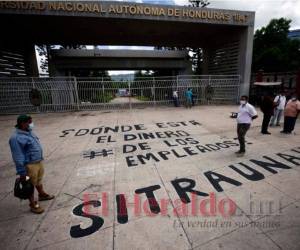Los trabajadores de la máxima casa de estudios protestaron la mañana del martes en la entrada principal de la UNAH. Foto: Emilio Flores / EL HERALDO.