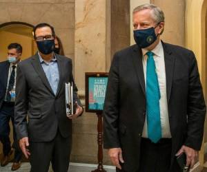 El jefe de despacho de la Casa Blanca Mark Meadows (derecha) y el secretario del Tesoro Steven Mnuchin llegan a la oficina de la presidenta de la Cámara de Representantes Nancy Pelosi en el Capitolio en Washington para reanudar sus conversaciones sobre un enorme proyecto de ley de alivio por la pandemia de COVID, el sábado 1 de agosto de 2020.