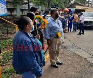 Un grupo de personas esperan que les entreguen sus familiares fallecidos en la entrada del Instituto Cardiopulmonar El Tórax, en esta ciudad capital de Honduras.