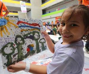 Esta hermosa pequeña muestra muy orgullosa su dibujo.
