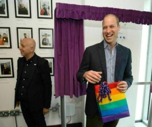 El príncipe William de Inglaterra, duque de Cambridge, reacciona al recibir un regalo del director ejecutivo del Albert Kennedy Trust, Tim Sigsworth, durante una visita para aprender sobre los problemas que enfrentan los jóvenes LGBTQ sin hogar, el miércoles 26 de junio del 2019 en Londres.