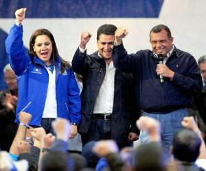 The president of Honduras, Porfirio Lobo (R), the Congress president Juan Orlando Hernandez (C) and his wife Ana of Hernandez (L), celebrate for his National Party presidential candidate election in Tegucigalpa, on November 19, 2012. AFP PHOTO / Orlando SIERRA