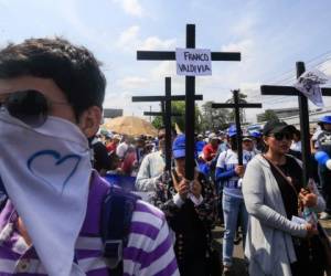 Manifestantes se suman a una procesión del Viacrucis del Viernes Santo en Managua, Nicaragua, y muestran pancartas en las que exigen la libertad de los presos políticos, el viernes 19 de abril de 2019. (AP Foto/Alfredo Zúñiga)