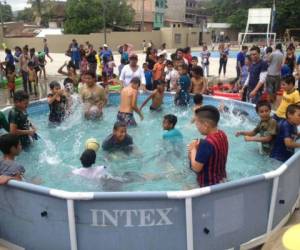 Un nutrido grupo de niños disfruta del baño en una piscina inflable en el parque Mi Esperanza, de la colonia Campo Cielo.