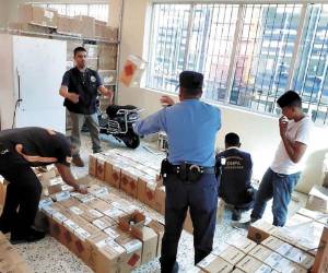 Personal de la Dirección Nacional Antidrogas y Agencia de Regulación Sanitaria inspeccionan las cajas con los químicos.