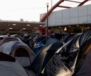 Familias enteras de migrantes esperan respuesta de asilo dentro de tiendas de campaña sobre el puente Gateway. Foto. AP