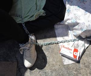 Una mujer permanece encadenada durante una huelga de hambre por los presos políticos este sábado, frente al centro penitenciario Zona 7 en Caracas, Venezuela. Familiares de presos políticos en Venezuela se unieron a una huelga de hambre iniciada por los detenidos, tras la liberación de 17 personas, incluidos sindicalistas y dos jóvenes con autismo. Aquí las imágenes de la actividad.