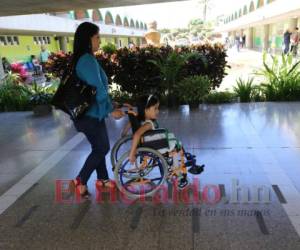 Los padres asisten al CRIT de Tegucigalpa con Keren cada semana para que reciba sus terapias de rehabilitación, ellos confían en que la niña caminará y dejará la silla de ruedas de la que depende. Foto: David Romero / EL HERALDO.