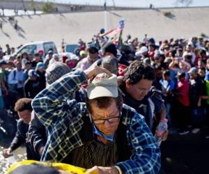 En esta foto del archivo del 25 de noviembre de 2018, los migrantes cruzan el río en la frontera entre Estados Unidos y México después de pasar una línea de la policía mexicana en el cruce de Chaparral en Tijuana, México, mientras intentan llegar a los Estados Unidos. Foto: AP.