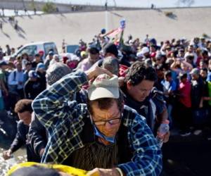 En esta foto del archivo del 25 de noviembre de 2018, los migrantes cruzan el río en la frontera entre Estados Unidos y México después de pasar una línea de la policía mexicana en el cruce de Chaparral en Tijuana, México, mientras intentan llegar a los Estados Unidos. Foto: AP.