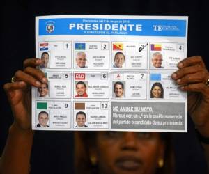 Un miembro del Tribunal Electoral muestra una papeleta durante el escrutinio de urnas. (Foto: AFP)