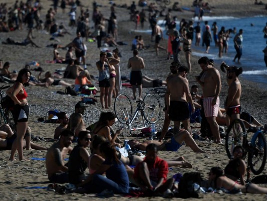 La gente toma el sol en la playa de la Barceloneta en Barcelona el 20 de mayo de 2020 durante las horas permitidas por el gobierno para hacer ejercicio, en medio del cierre nacional para evitar la propagación de la enfermedad COVID-19. Foto: Agencia AFP.