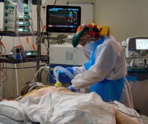 Un trabajador sanitario atiende a un paciente con coronavirus en la Unidad de Cuidados Intensivos del hospital Príncipe de Asturias en Alcalá de Henares. Foto AFP