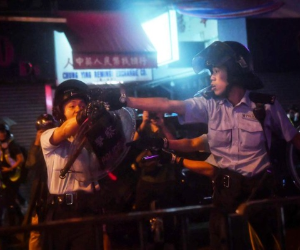 Los oficiales de policía apuntan con sus armas a los manifestantes en Tseun Wan en Hong Kong. Foto: Agencia AFP.