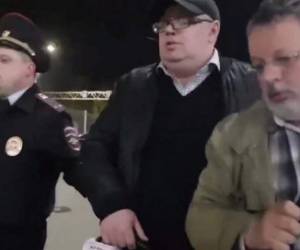 Dmitry Khlebushkin es custodiado por las autoridades para salvarlo de las personas que lo intentaron agredir.