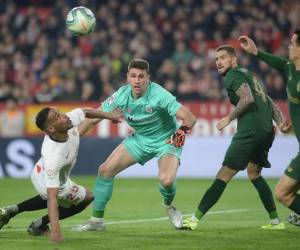 El centrocampista brasileño de Sevilla, Fernando, compite con el portero español del Athletic de Bilbao, Unai Simon. Foto: Agencia AFP.