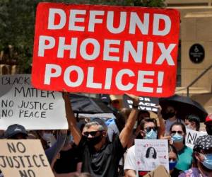 Manifestantes piden que se deje de financiar a la policía durante una protestas por la muerte de George Floyd en Phoenix. (AP Photo/Matt York)