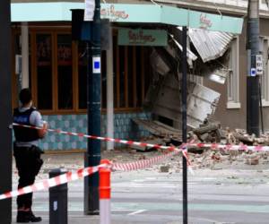 Un agente de policía cierra una intersección donde cayeron escombros sobre la calle después de un sismo en Melbourne, Australia, el miércoles 22 de septiembre de 2021. (James Ross/AAP Image vía AP)